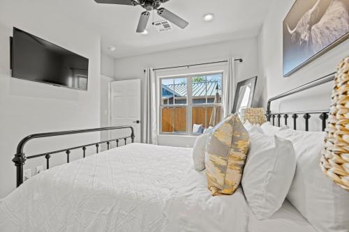 a bedroom with a white bed with a ceiling fan at *Brand New Listing* Romantic Getaway Near Main in Fredericksburg