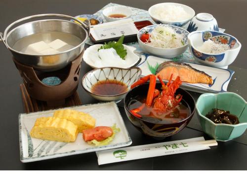 uma mesa coberta com diferentes tipos de alimentos em pratos em Yamashichi em Toba