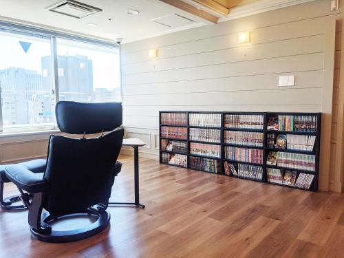 a library with a chair and a book shelf with books at Hotel Wing International Shizuoka in Shizuoka