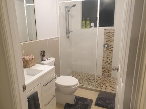 a bathroom with a shower and a toilet and a sink at Hostel-Style GUESTHOUSE - for 18-40yrs in Caloundra