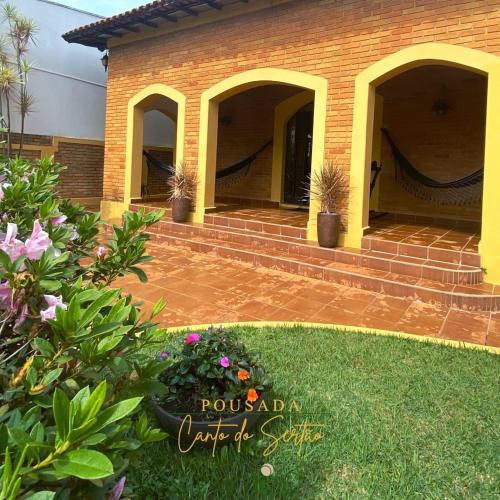 Pousada Canto do Sertão في ساو ميجيل اركانخو: منزل به فناء وساحة بها زهور