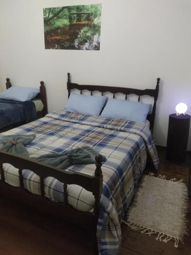 a bedroom with a bed with a blue and white blanket at Pousada Canto do Sertão in São Miguel Arcanjo