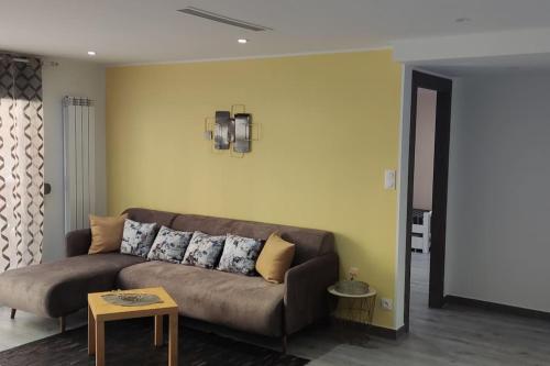 un soggiorno con divano marrone e tavolo di Appartement F3 moderne en Résidence a Ouled Moussa