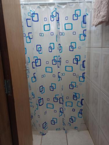 uma cortina de chuveiro com quadrados azuis na casa de banho em PousadaTopFest em Poços de Caldas
