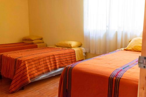a room with two beds and a window at Casa Esperanza in Panajachel