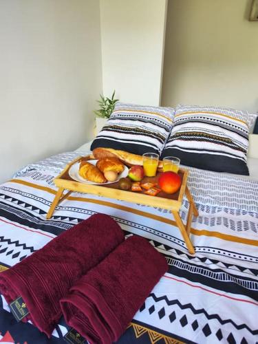 a tray of fruit and drinks on a bed at Peaceful cocoon in Chatou