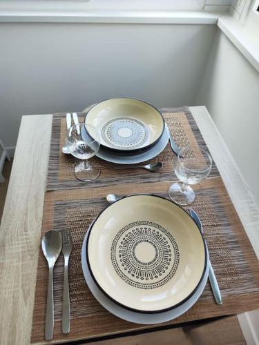 a table with two plates and wine glasses on a table at Peaceful cocoon in Chatou
