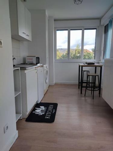 a room with a kitchen with a table and a microwave at Peaceful cocoon in Chatou