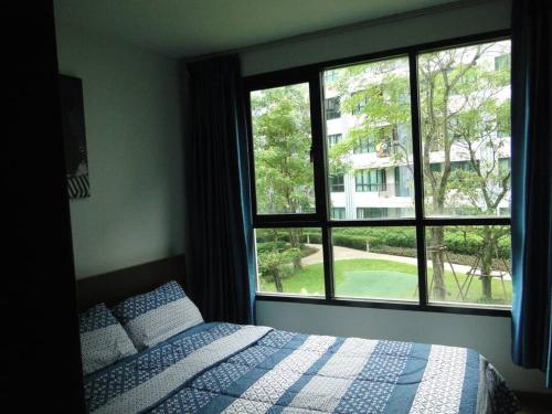 a bedroom with a bed and a large window at Apartment near Central phuket in Phuket