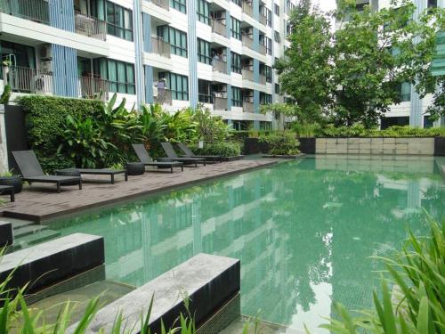 a swimming pool in front of a building at Apartment near Central phuket in Phuket