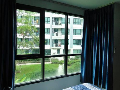 a bedroom with a window with a view of a building at Apartment near Central phuket in Phuket