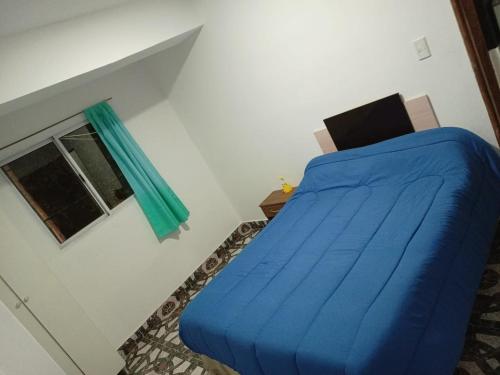 Un dormitorio con una cama azul y una ventana en Mi cielo en Santa María
