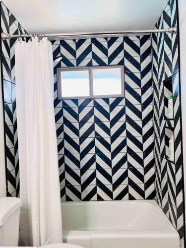 a bathroom with a black and white patterned wall at Stylish home in the heart of Tempe w/ private pool in Tempe