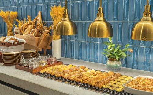 a buffet with pastries and other food on a counter at Wyndham Xiong'an in Baoding
