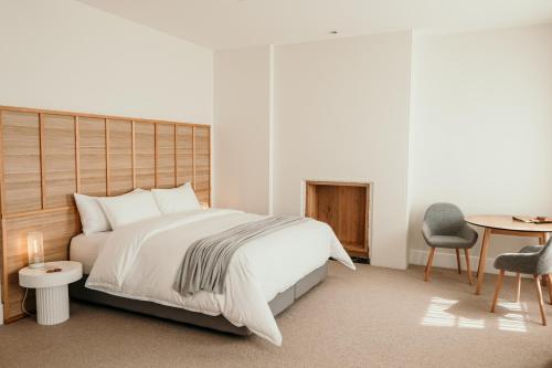 a bedroom with a bed and a table and a chair at The Oak & Anchor Hotel in Port Fairy