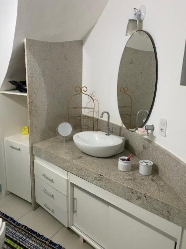 a bathroom with a sink and a mirror at CASA DE REVISTA em Cabo Frio in Cabo Frio