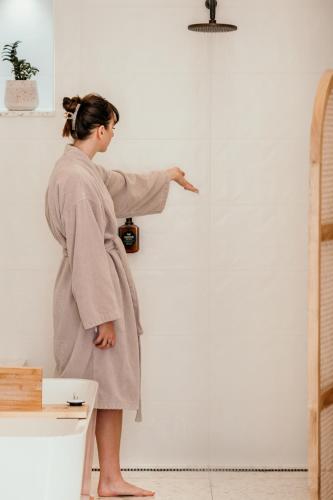 a woman in a robe pointing at a wall at The Oak & Anchor Hotel in Port Fairy