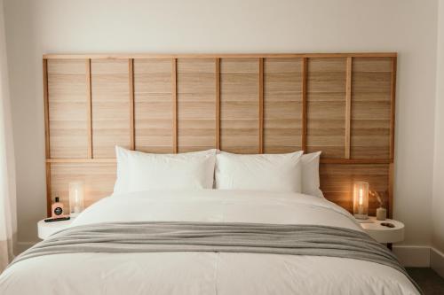 a bedroom with a large bed with a wooden headboard at The Oak & Anchor Hotel in Port Fairy