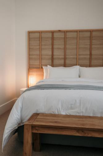 a bed with a wooden headboard and a wooden table at The Oak & Anchor Hotel in Port Fairy