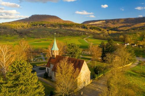 una vecchia chiesa in mezzo a un campo verde di Ferienwohnungen beim Imker a Mössingen