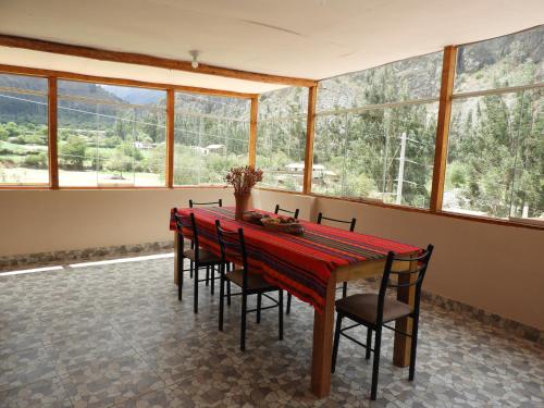 a dining room with a red table and chairs at Ayllu B&B Ollantaytambo in Ollantaytambo