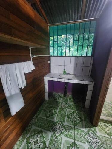 baño con lavabo y ventana en Refugio Valverde Alonso, en Puerto Jiménez