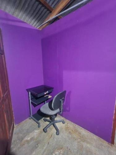 Habitación púrpura con escritorio y silla en Refugio Valverde Alonso, en Puerto Jiménez