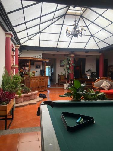 a pool table in a living room with a ceiling at Hostal Casa Gaia in San Cristóbal de Las Casas