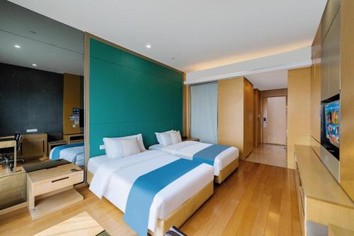 a large bedroom with two beds and a flat screen tv at eStay Residence·Poly World Trade Center Guangzhou in Guangzhou