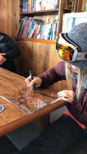 a woman sitting at a table working on a piece of wood at A short walk to Akakura Onsen Ski Lift and Town by Japow House in Myoko