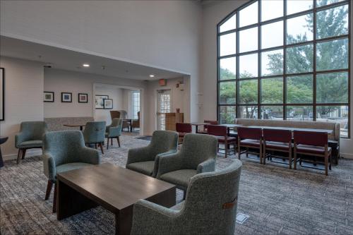 a waiting room with chairs and tables and windows at Staybridge Suites Allentown Airport Lehigh Valley by IHG in Allentown