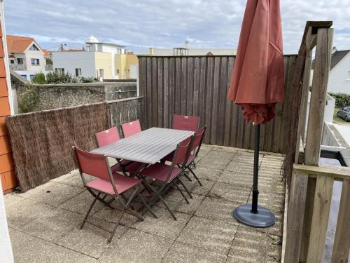 - une table, des chaises et un parasol sur la terrasse dans l'établissement Tourmaline - Vue Mer & Fort - Confort & Evasion, à Ambleteuse