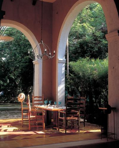 a table and chairs sitting under an arch way at Hacienda San Jose Cholul in Tixkokob