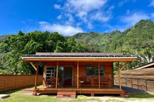 uma pequena casa com um telhado em cima em Fare Te Ava - Comfy cabin w Private Beach Access em Haapiti