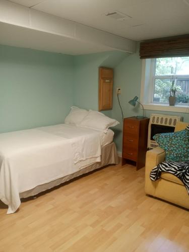 a bedroom with a bed and a chair and a window at University Heights Central 2 BRM in Athens