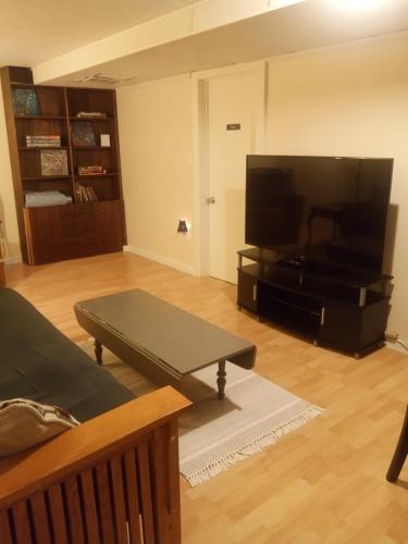 a living room with a table and a large screen tv at University Heights Central 2 BRM in Athens