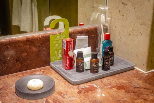 a bathroom counter with bottles of essential oils and a mirror at Camino Real Pedregal Mexico in Mexico City