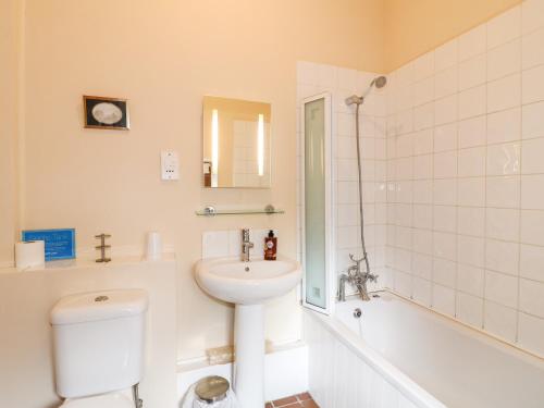 a bathroom with a sink and a toilet and a tub at Manifold Cottage in Grindon