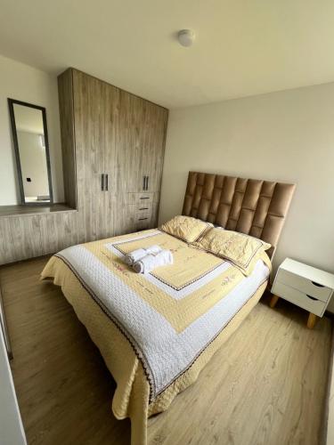ein Schlafzimmer mit einem großen Bett und einem Spiegel in der Unterkunft Nuevo Apartamento frente al Centro Comercial VIVA in Tunja