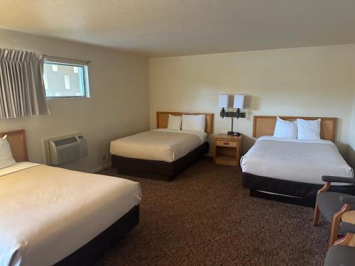 a hotel room with two beds and a window at Big Bend Traveler's Inn in Great Bend