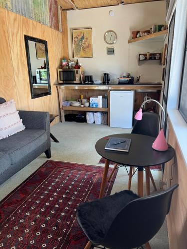 Tawharanui的住宿－Kākā Ridge Retreat Bush Hideaway，客厅配有沙发和桌子