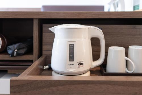 a white appliance is sitting in a drawer at Super Hotel Tokyo JR Tachikawa Kitaguchi in Tachikawa