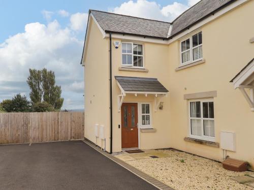 Casa blanca con puerta de madera y valla en Shore View, en Grange-over-Sands