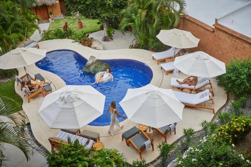 - une vue sur la piscine bordée de parasols dans l'établissement La Villa Luz (sólo adultos), à Zihuatanejo