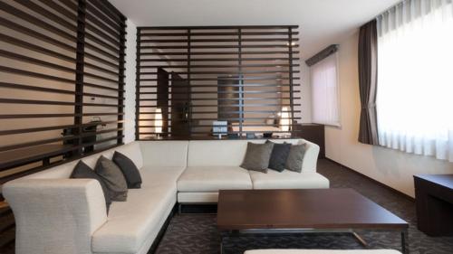 a living room with a white couch and a table at Onomichi Kokusai Hotel in Onomichi