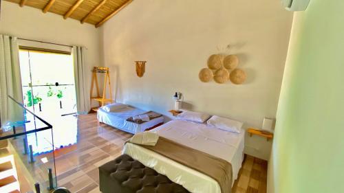 1 dormitorio con 2 camas y balcón en Chalés Oliveira, en Ilhabela