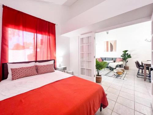 ein Schlafzimmer mit einem roten Bett und ein Wohnzimmer in der Unterkunft Serene Town home in Chandler with pool in Chandler