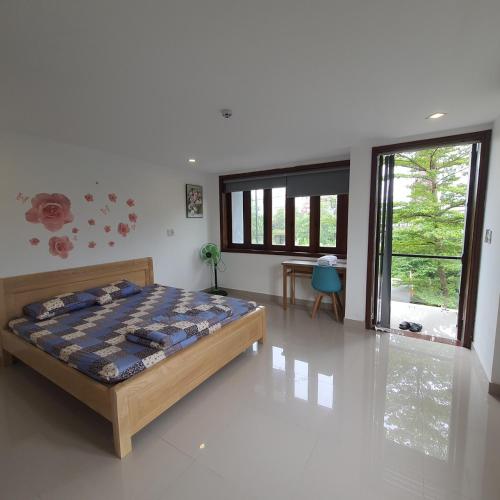 a bedroom with a bed and a large window at KempiB Homestay NGUYÊN CĂN - đậu nhiều ô tô in Hue