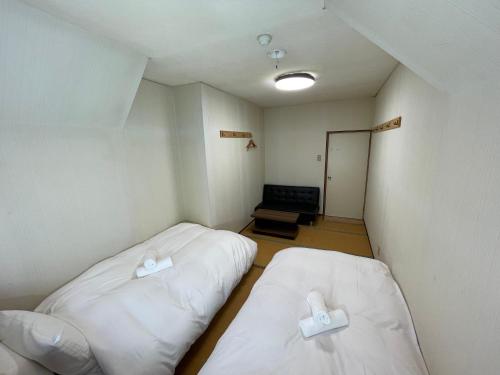 a small room with two beds and a couch at A short walk to Akakura Onsen Ski Lift and Town by Japow House in Myoko