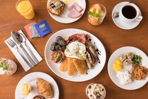 a table with plates of food and a cup of coffee at Distinction Dunedin Hotel in Dunedin